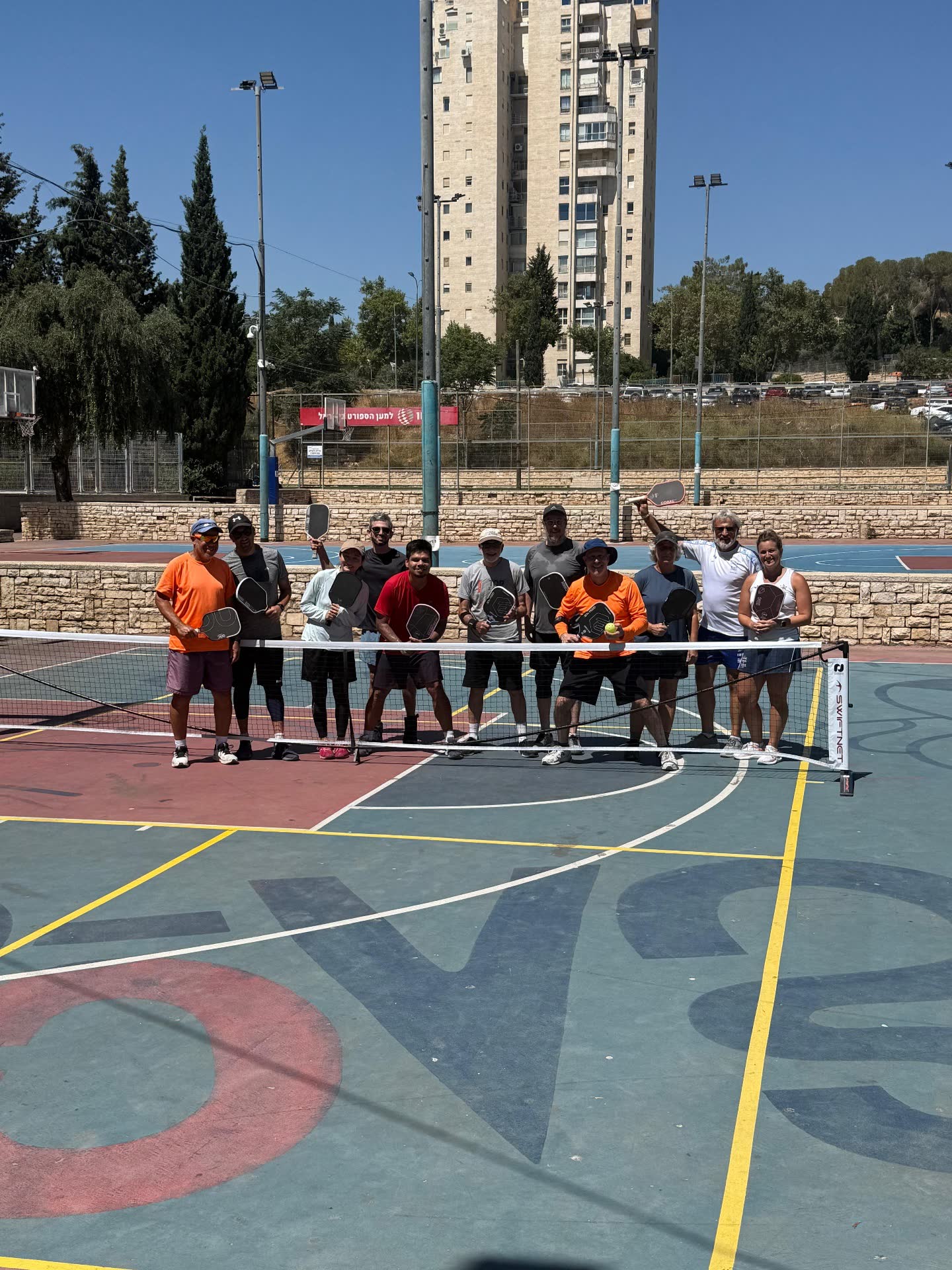 Jerusalem Pickleball Club group photo at the net, July 2026